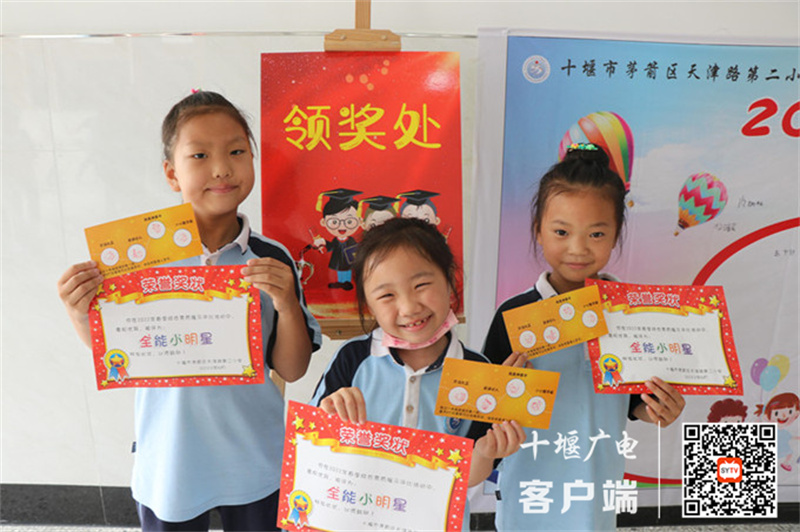 学生挥舞着手中的闯关卡和奖状