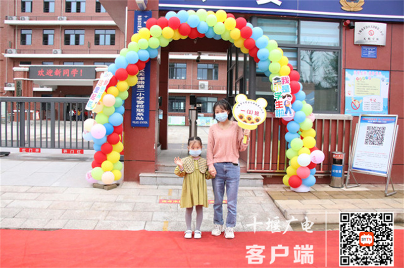 老师和学生在气球门前合影