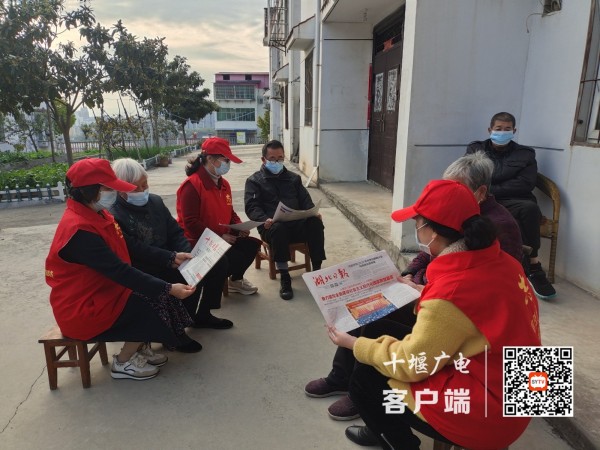 教师志愿者走近老人为他们读报纸宣传学习二十大精神