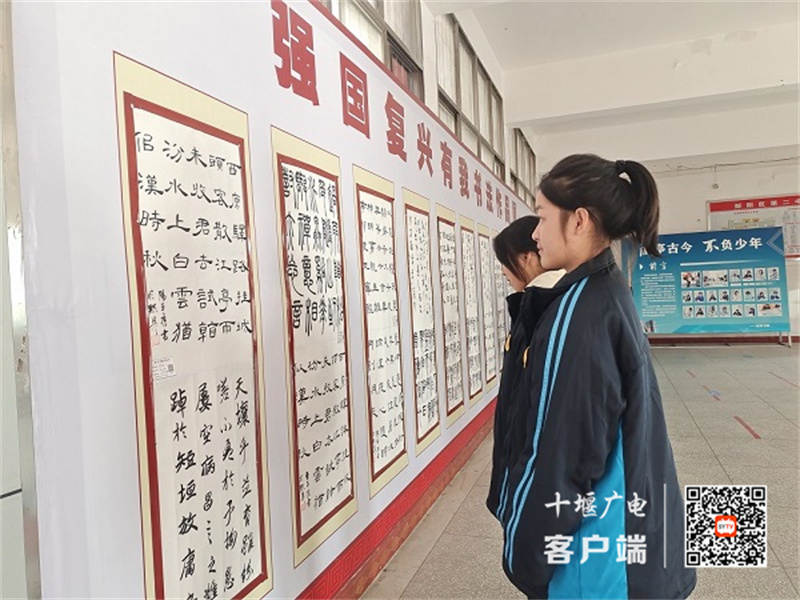 驻足欣赏书法作品的同学们